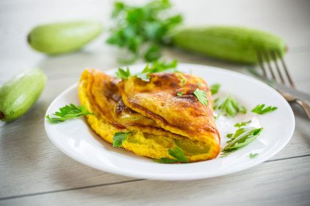 Fried omelet with zucchini,in a plate on a wooden table.の写真素材