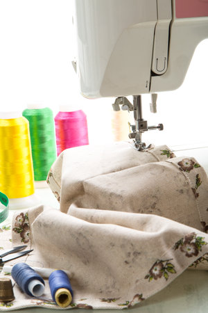 Sewing machine with fabric and threads for sewing, close-up. The working process. Part of a sewing machine with fabric.の写真素材
