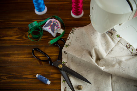 a set of tools and threads for sewing clothes, on a wooden background.の写真素材