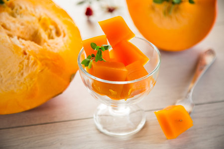 Prepared sweet pumpkin marmalade in a glass bowl on a wooden table. Autumn recipes.の写真素材