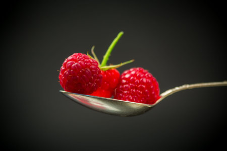 Ripe red raspberries closeup, isolated on black background.