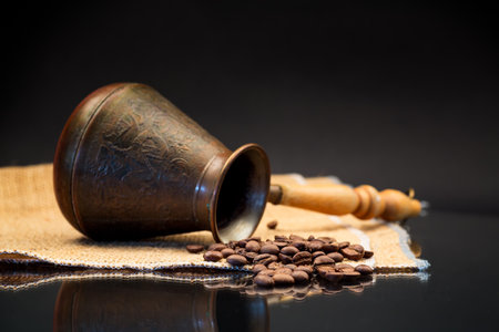 natural coffee beans, Turkish coffee pot on burlap, isolated on a black backgroundの写真素材