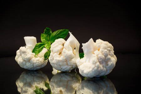 slices of raw small raw cauliflower isolated on black backgroundの写真素材