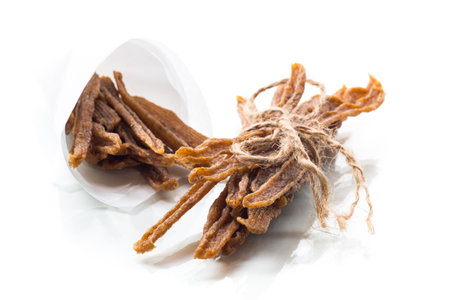 A handful of dried chicken meat, marinated with spices, isolated on a white background. Beer spicy snack.の写真素材