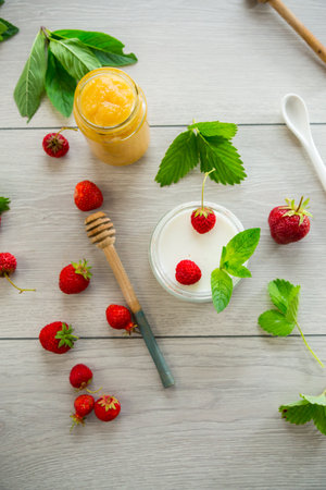 homemade sweet yogurt in a jar with strawberries, on a wooden table.の写真素材