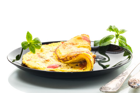 fried omelette with sweet pepper and vegetables in a plate, isolated on white background.の写真素材