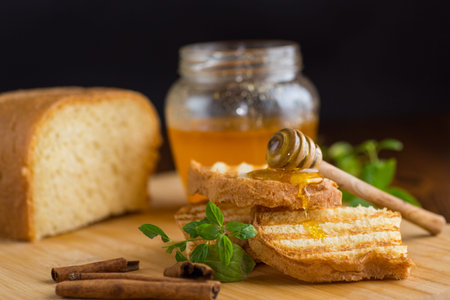 bread fried sweet toasts with honey on wooden board with cinnamon.