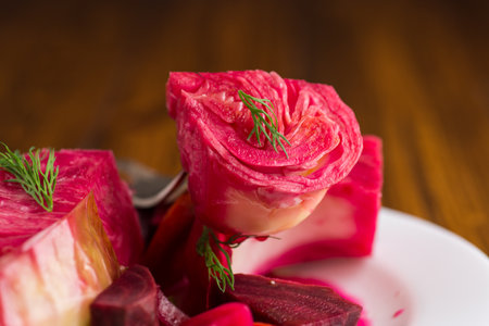 pickled cabbage with beets and carrots, in a plate, on a wooden table.の写真素材