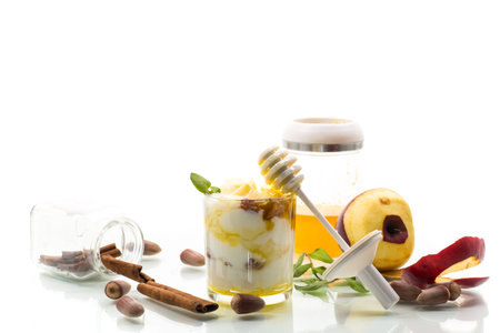 sweet homemade yogurt in a glass with apples, nuts and honey.の写真素材