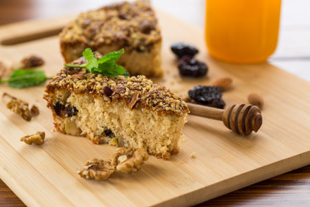 Sponge cake with prunes and nuts on wood.