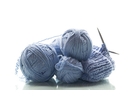 Blue yarn with knitting, isolated on white background.の写真素材
