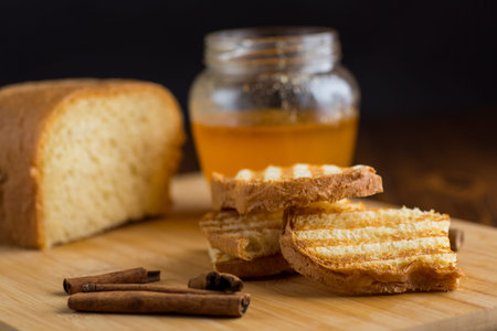 bread fried sweet toasts with honey on wooden board with cinnamon.