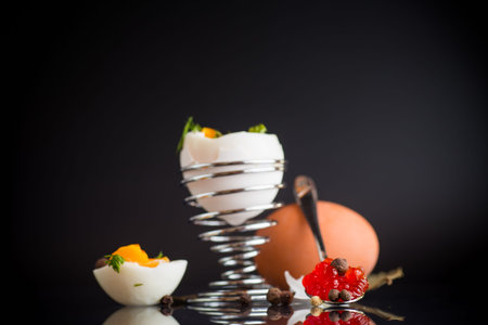delicacy with red caviar and boiled egg for breakfast, isolated on black background.