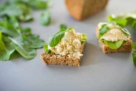 Homemade rye bread with herring paste and arugula.