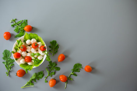 Appetizing serving of mini mozzarella with greens and tomatoes.