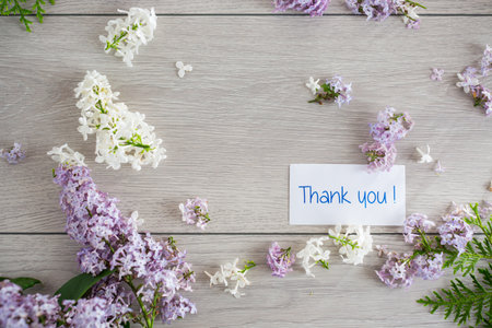 Flower frame of white and purple lilac with gratitude on light wooden background.の写真素材