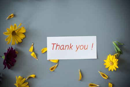 Yellow and purple flowers arrangement with petals on gray background.の写真素材