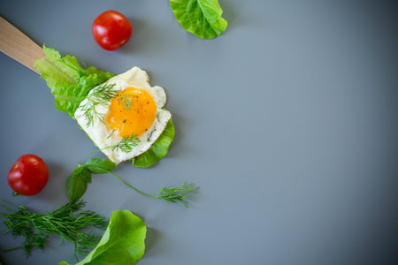 Close-up of healthy food, egg and salad on spatula, on gray background.の写真素材