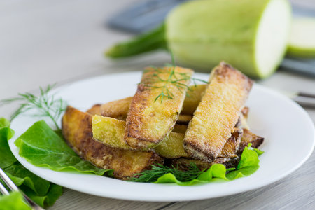 Homemade fried zucchini on a white plate.の写真素材