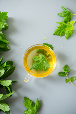 Green tea from currant leaves and mint in a glass container.の写真素材