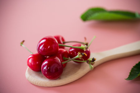Ripe red cherries on pink background from above.の写真素材