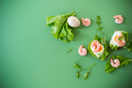 Appetizing breakfast with shrimp, egg and greens on top.の写真素材