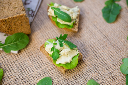 Sandwich with herring paste and greens on a burlap tablecloth.の写真素材