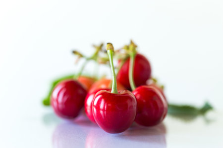 a handful of ripe red cherries on a white background.の写真素材