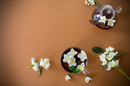 Freshly brewed tea with jasmine flowers on a brown background.の写真素材