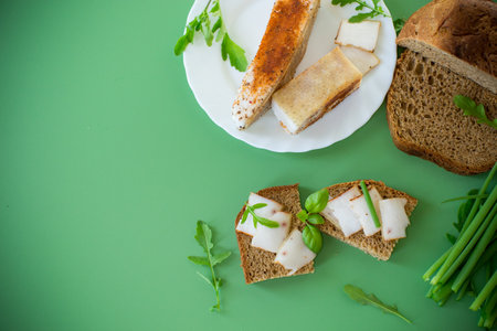 Traditional Ukrainian dish with lard and greens on a green background.の写真素材
