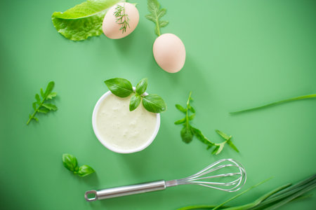 Top view of homemade mayonnaise with green herbs and eggs.の写真素材