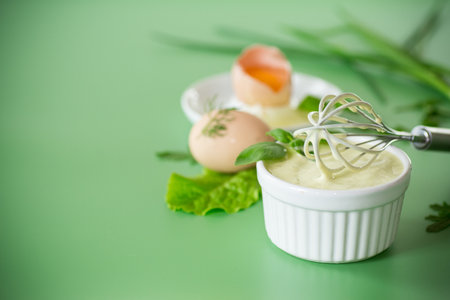 Top view of homemade mayonnaise with green herbs and eggs.の写真素材