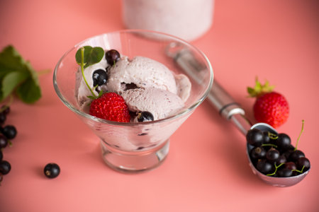 Blackcurrant ice cream with strawberries on pink background.の写真素材