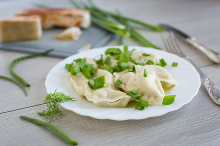 Appetizing dumplings with potatoes and onions on a rustic table.の写真素材