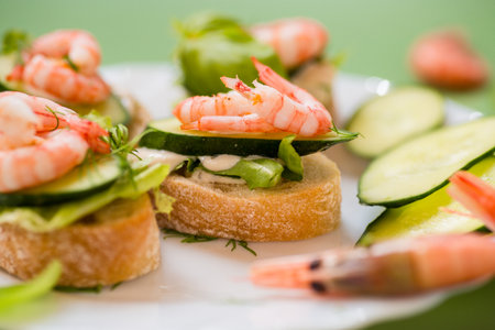 Appetizing appetizers with shrimps, sauce and cucumbers on a green background.の写真素材