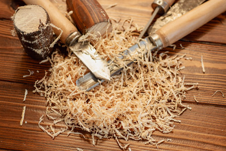 Close up of wood carving with sawdust on wooden table.