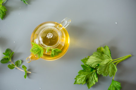 Natural green tea with herbs in glass on a gray background.の写真素材