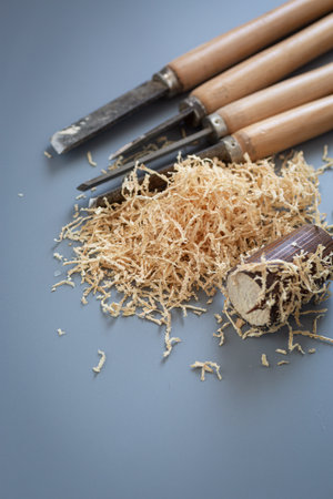 Chisels and wood shavings in craftsman's workshop on gray background.の写真素材