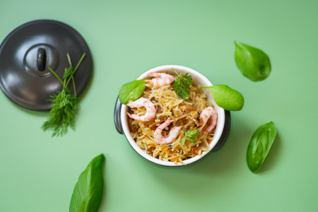 Asian dish of rice and shrimps on a green background.の写真素材