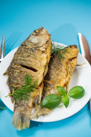 Delicious juicy crucian carp with an appetizing crust, served for dinner.の写真素材