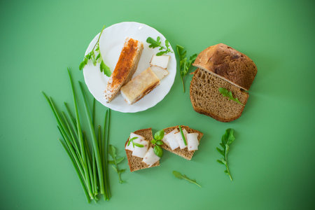 Sandwich with lard on rye bread and green onions on top.