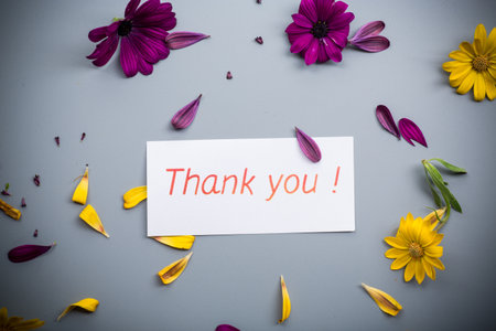 Purple and yellow flower arrangement on gray background.の写真素材