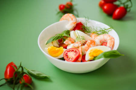 Delicious seafood salad with egg and basil on a green background.の写真素材