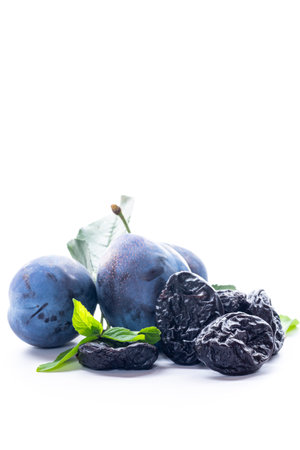 Fresh summer plums and rustic dried prunes closeup.の写真素材