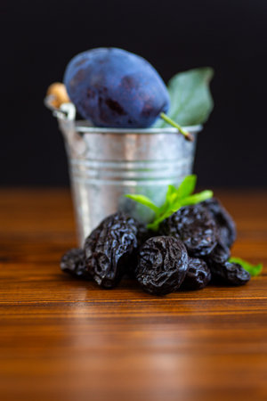 Fresh plum and dried prunes with rustic wooden table.の写真素材