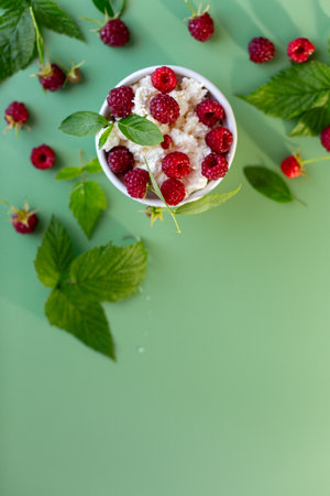 Natural cottage cheese with red raspberries and greens close-up.の写真素材