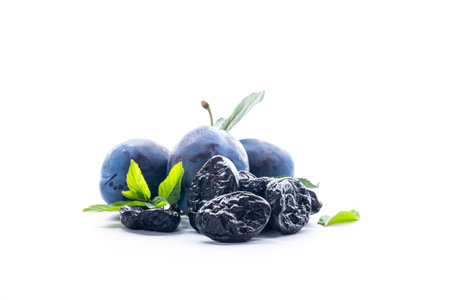 Fresh ripe plums and dried prunes isolated on white.の写真素材