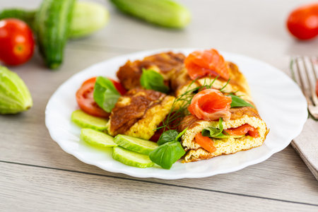Omelet with salmon and green leaves for a healthy breakfast.
