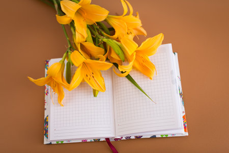 Greeting card scene with lilies and open planner.の写真素材