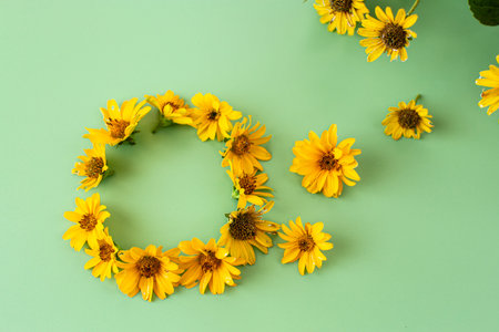 Blooming yellow flowers with natural leaves on green background.